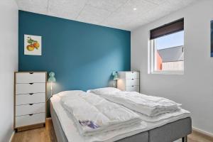 une chambre avec un mur bleu et un lit dans l'établissement 943-Hvide-Sande-Langsand-165, à Hvide Sande