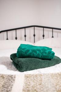 ein grünes Kissen auf dem Bett in der Unterkunft Cozy home in Kings Lynn