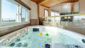 eine Badewanne mit zwei Gummienten darin in der Unterkunft Ganghwa Hanabi Pension in Incheon + 16 Fotos