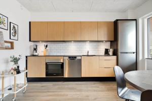 een keuken met houten kasten en roestvrijstalen apparatuur bij 908-Hvide-Sande-Langsand-102-stuen in Hvide Sande