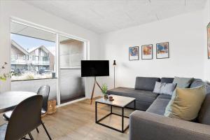 een woonkamer met een bank en een tafel bij 908-Hvide-Sande-Langsand-102-stuen in Hvide Sande