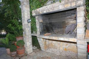 una chimenea de piedra en un patio con macetas en Apartments Moreta, en Biograd na Moru