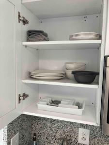 een keukenkast met borden en kommen op planken bij sunset cottage in West Palm Beach +8 foto's