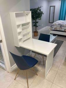 een wit bureau en een blauwe stoel in een kamer bij sunset cottage in West Palm Beach