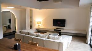 a living room with a white couch and a flat screen tv at Villa Nata Umalas in Seminyak