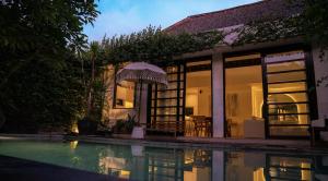 a house with a swimming pool in front of it at Villa Nata Umalas in Seminyak