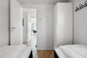 twee bedden in een kamer met witte muren bij 944-Hvide-Sande-Langsand-143 in Hvide Sande