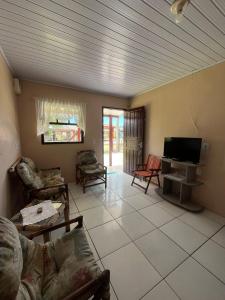 a living room with a couch and a flat screen tv at Recanto do descanso in Pinhal