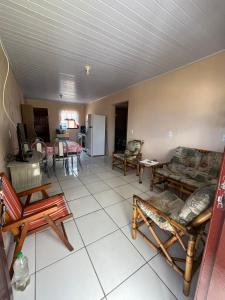 a living room with couches and chairs and a kitchen at Recanto do descanso in Pinhal +3 photos
