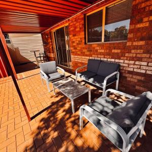 a patio with two chairs and a couch and a table at Live, Laugh, Lodge - Central 3x2 in Kalgoorlie