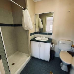 a bathroom with a toilet and a sink and a shower at Live, Laugh, Lodge - Central 3x2 in Kalgoorlie +8 photos