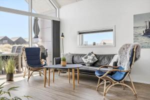 een woonkamer met een bank, stoelen en een tafel bij 905-Hvide-Sande-Langsand-80 in Hvide Sande