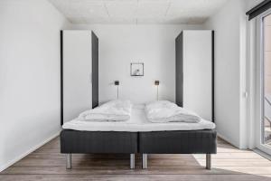 een bed in een kamer met witte muren bij 905-Hvide-Sande-Langsand-80 in Hvide Sande