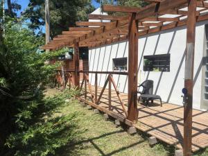 een houten terras met een pergola op een huis bij CABAÑAS CAMPO y MAR in Playa Dorada