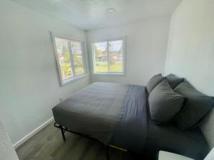 a bedroom with a bed and two windows at Bogachiel Den in Forks