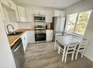 a kitchen with white cabinets and a table with chairs at Bogachiel Den in Forks