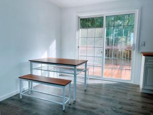 a table and a bench in a room with a window at The Sitka Spruce House in Forks