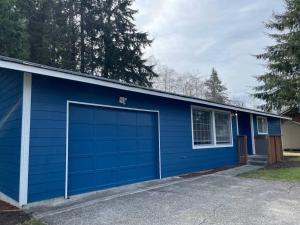 a blue garage building with a blue door at The Sitka Spruce House in Forks