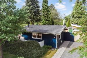 een blauw huis midden in een tuin bij 8159-Praesto-Vagtelvej-8 in Præstø