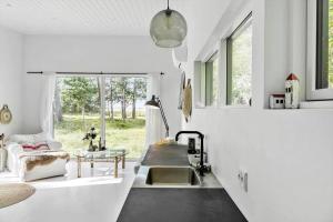 een witte keuken met een wastafel en een tafel bij 2029-Stege-Telefonstien-41 in Stege