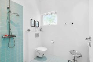 een badkamer met douche en toilet en een raam bij 2029-Stege-Telefonstien-41 in Stege +20 foto's