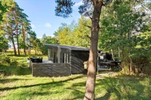 een kleine hut in een veld met een boom bij 2029-Stege-Telefonstien-41 in Stege