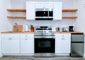a kitchen with white cabinets and a stove and a microwave at The Sitka Studio in Forks