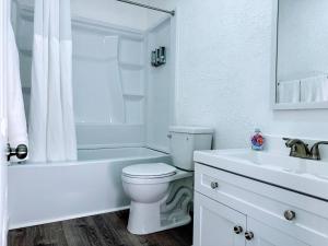 a white bathroom with a toilet and a sink at The Sitka Studio in Forks