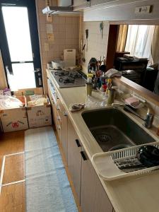 eine Küche mit Spüle und Herd in der Unterkunft Okegawa Quiet Homestay in Okegawa