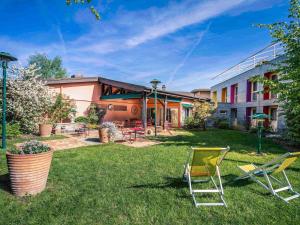 een tuin met twee stoelen en een gebouw bij Mercure Bourg En Bresse in Bourg-en-Bresse