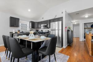 a kitchen and dining room with a table and chairs at Modern 3BR Near NYC with Pool Table Sleeps 11 in Jersey City +19 photos