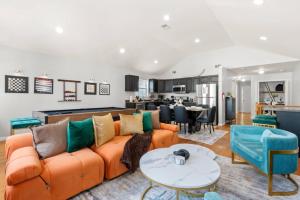 a living room with an orange couch and a table at Modern 3BR Near NYC with Pool Table Sleeps 11 in Jersey City