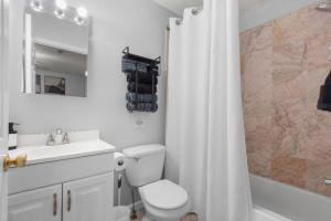 a bathroom with a toilet and a sink and a shower at Modern 3BR Near NYC with Pool Table Sleeps 11 in Jersey City