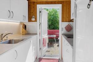 a kitchen with a sink and a door to a yard at 5011-Askeby-Faergensvaenge-17 in Askeby +14 photos