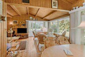 a living room with wooden walls and a table and chairs at 5011-Askeby-Faergensvaenge-17 in Askeby