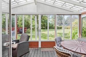 a screened in porch with a table and chairs at 5011-Askeby-Faergensvaenge-17 in Askeby