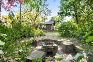 un cortile con buca per il fuoco e una casa di 8229-Lundby-Stenurtvej-6 a Lundby