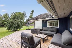 eine Terrasse mit Sofa, Stühlen und einem Tisch in der Unterkunft FA037 Faxe Ladeplads - Strandlodden 54 in Fakse Ladeplads