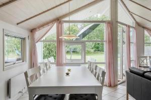 ein Esszimmer mit einem Tisch und einem großen Fenster in der Unterkunft FA037 Faxe Ladeplads - Strandlodden 54 in Fakse Ladeplads + 14 Fotos