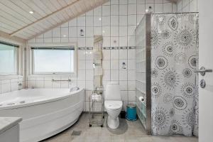 ein Badezimmer mit Badewanne, Toilette und Dusche in der Unterkunft FA037 Faxe Ladeplads - Strandlodden 54 in Fakse Ladeplads