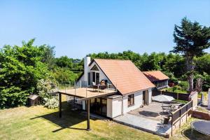 een klein wit huis met een oranje dak bij 4231-Stege-Nymarksvej-21 in Stege