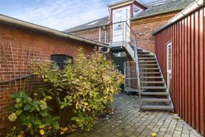 una scala che porta a un edificio di mattoni di 4264-Stege-Storegade-64-Baghuset a Stege
