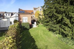 un ampio cortile con una casa e alberi di 4264-Stege-Storegade-64-Baghuset a Stege