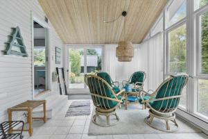 a porch with chairs and a table and windows at 3006-Stege-Bunden-6 in Stege