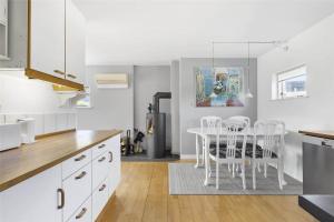 een keuken met een witte tafel en witte stoelen bij S740-Stroby-Ladeplads-Lovsangervej-33 in Strøby Ladeplads