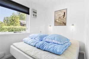 een kamer met drie kussens op een bed met een raam bij S740-Stroby-Ladeplads-Lovsangervej-33 in Strøby Ladeplads