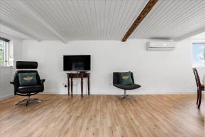 een kamer met 2 stoelen en een flatscreen-tv bij 4320-Stege-Oddermose-Strandvej-5-B in Stege