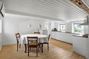 een keuken en eetkamer met een tafel en stoelen bij 4320-Stege-Oddermose-Strandvej-5-B in Stege +14 foto's