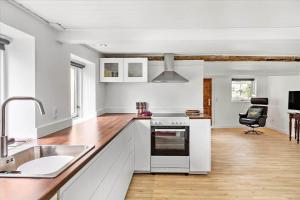 een witte keuken met een spoelbak en een fornuis bij 4320-Stege-Oddermose-Strandvej-5-B in Stege