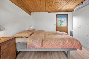 een slaapkamer met een bed en een houten plafond bij 4320-Stege-Oddermose-Strandvej-5-B in Stege